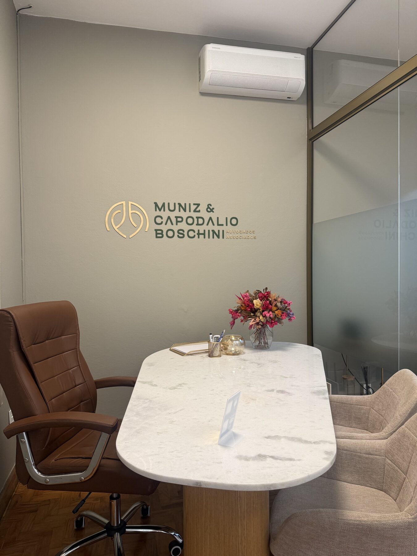 Segunda sala de atendimento, com a marca do escritório aplicada na parede