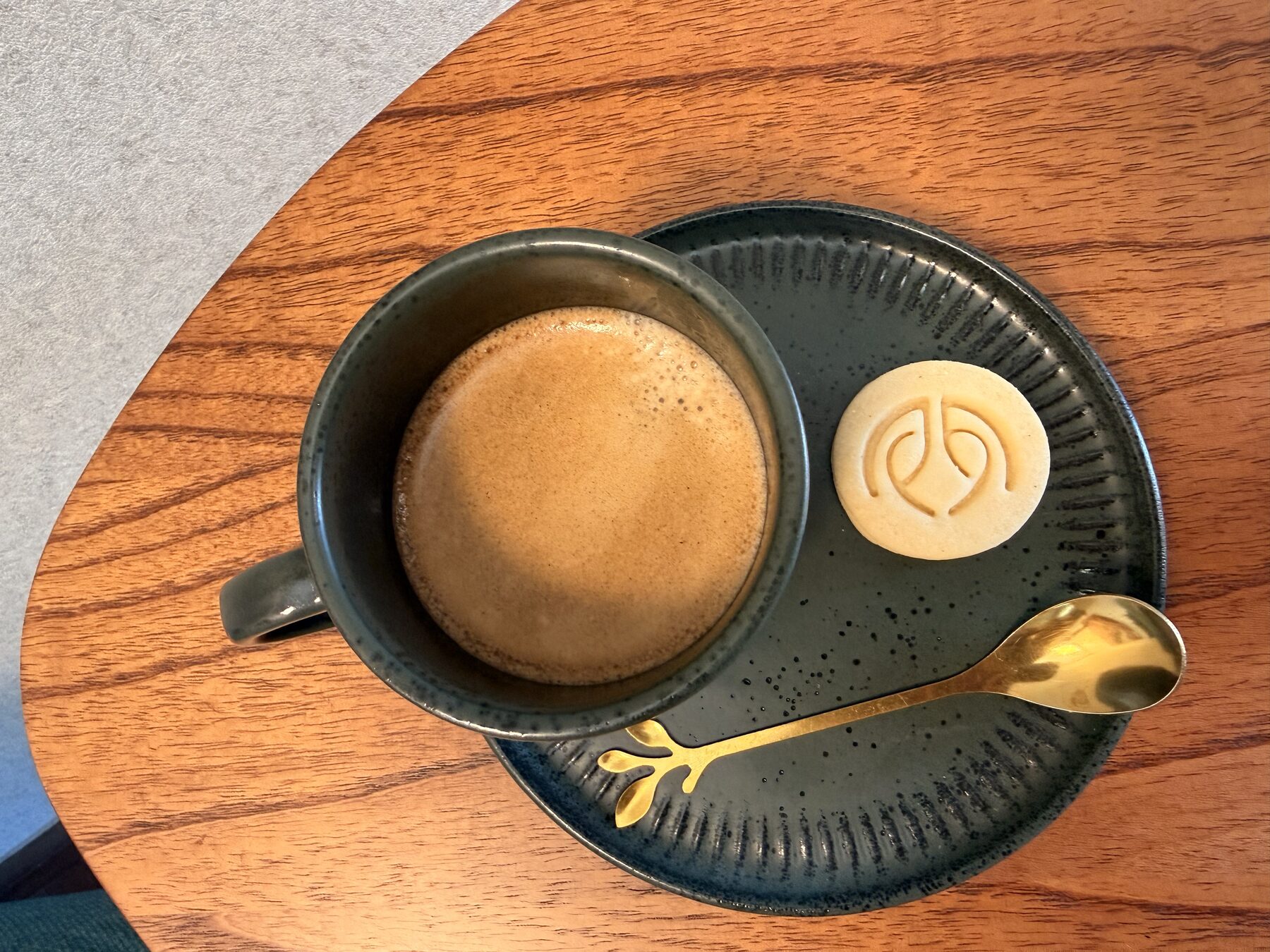 Café e biscoite com a marca do escritório servidos sobre a mesa